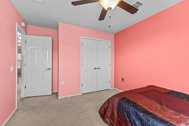 a bedroom with a bed and a chandelier fan