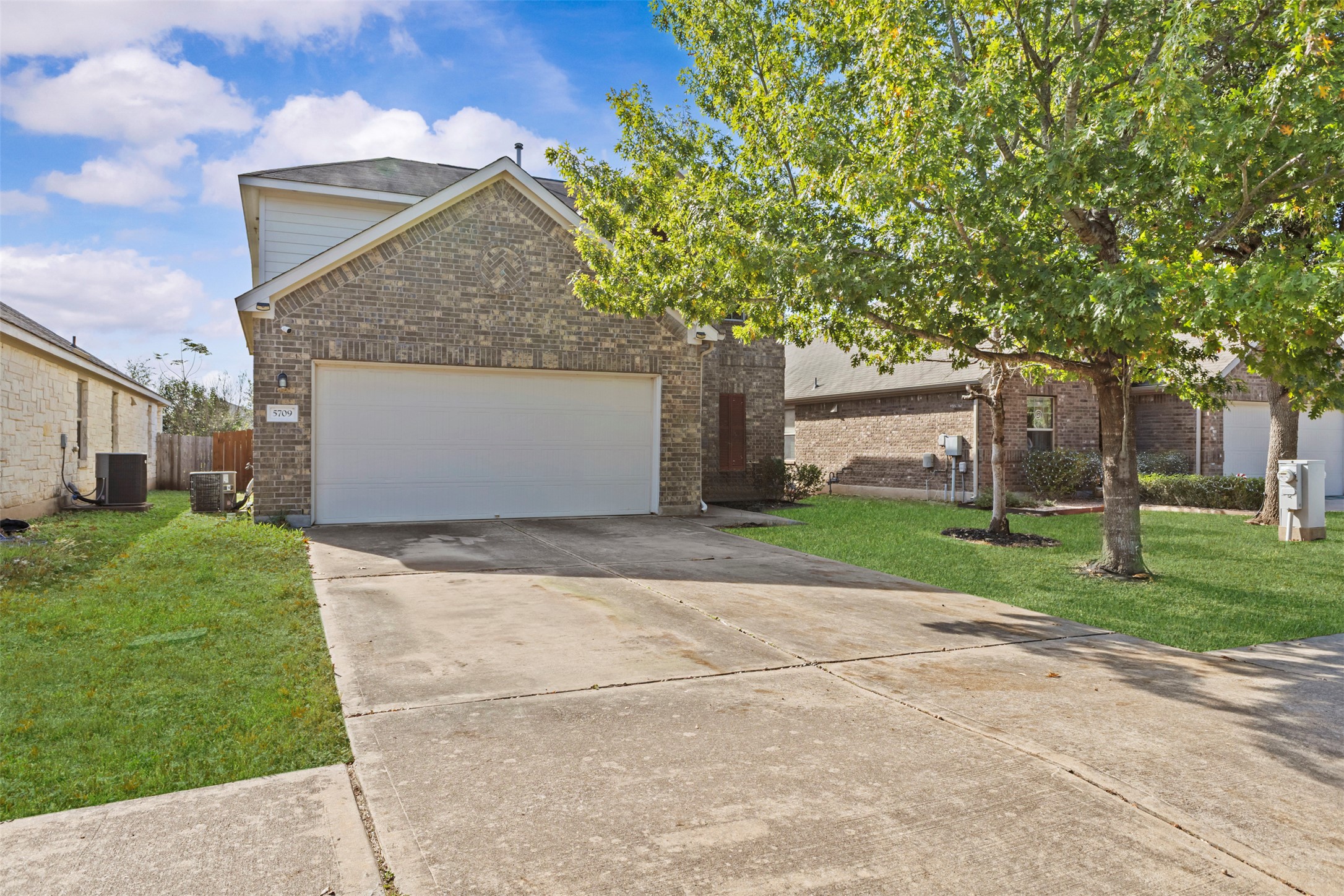 5709 Zachary Scott Street Austin, TX 78747 - Photo 3 of 29 a front view of a house with a yard and garage