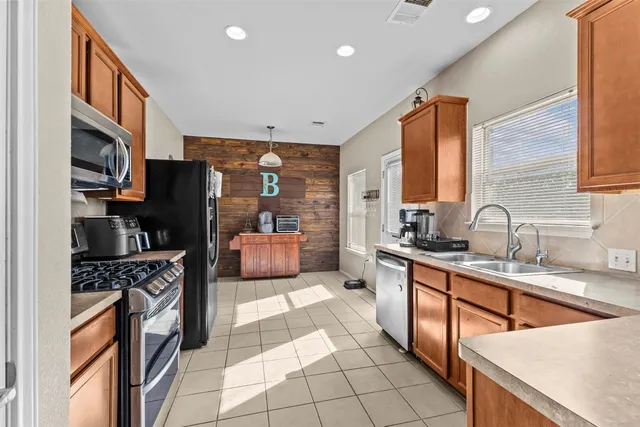 a kitchen with stainless steel appliances a sink stove refrigerator and cabinets