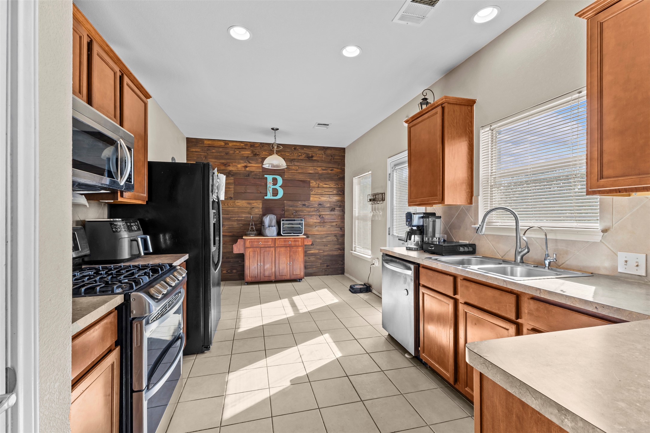 5709 Zachary Scott Street Austin, TX 78747 - Photo 8 of 29 a kitchen with stainless steel appliances a sink stove refrigerator and cabinets