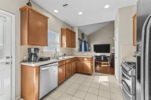 a kitchen with stainless steel appliances granite countertop a sink stove and refrigerator