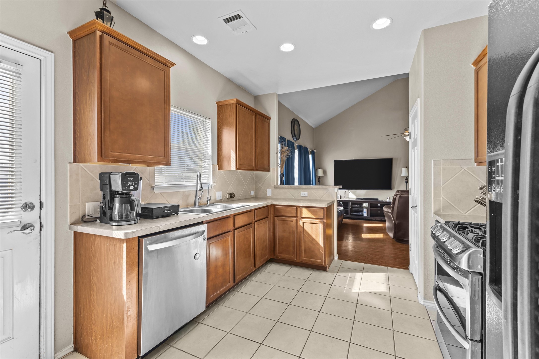 5709 Zachary Scott Street Austin, TX 78747 - Photo 9 of 29 a kitchen with stainless steel appliances granite countertop a sink stove and refrigerator