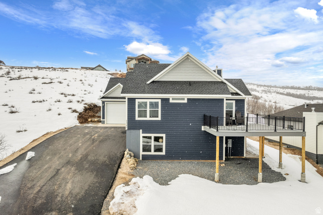 1343 North Trapper Loop Garden City, UT 84028 - Photo 53 of 56 Snow covered house with a garage, a wooden deck, asphalt driveway, and roof with shingles