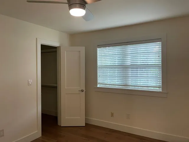 an empty room with wooden floor and a window