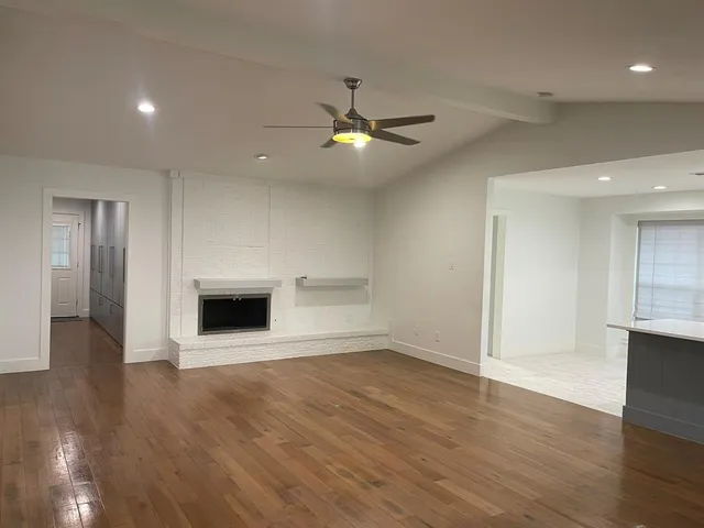 wooden floor in an empty room with a kitchen