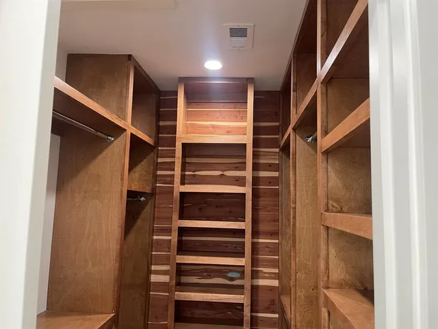 a view of walk in closet with empty racks