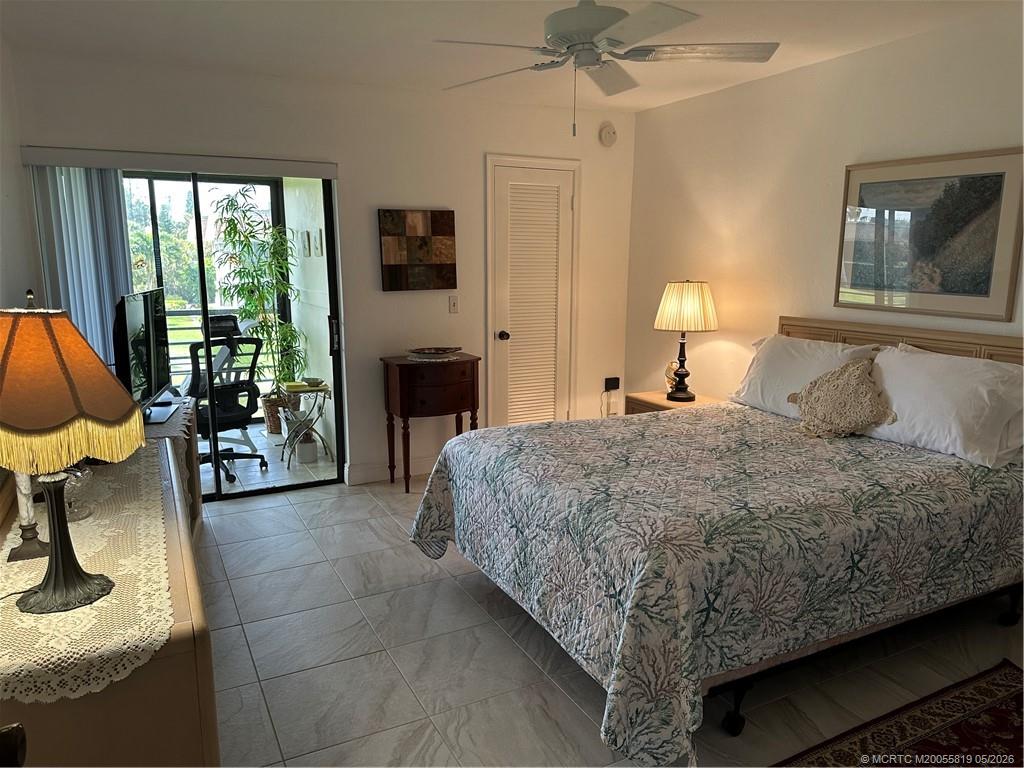 755 Saturn Street, Unit F205 Jupiter, FL 33477 - Photo 10 of 19 a bedroom with a bed chair and fireplace