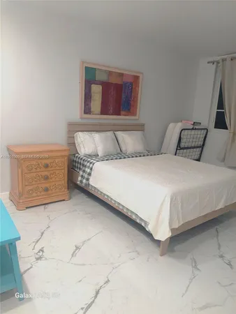 a bedroom with a bed and a painting on the wall
