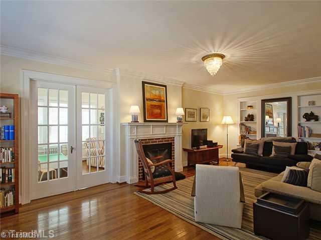 2109 Rolling Road Greensboro, NC 27403 - Photo 3 of 16 Living Room. Living room has wood mantel over fireplace with two outlets. Built in book/display shelves surround doorway (behind mirror) to sitting room. Crown molding, french doors and period light fixture highlight the charm of this older but well preserved home.