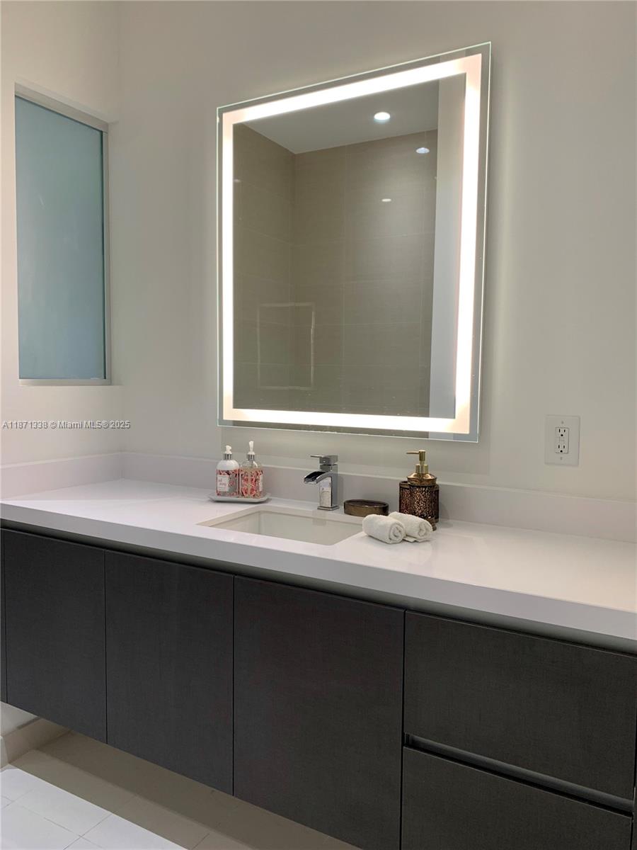 851 Northeast 1st Avenue, Unit 502 Miami, FL 33132 - Photo 13 of 48 a bathroom with a double vanity sink and mirror