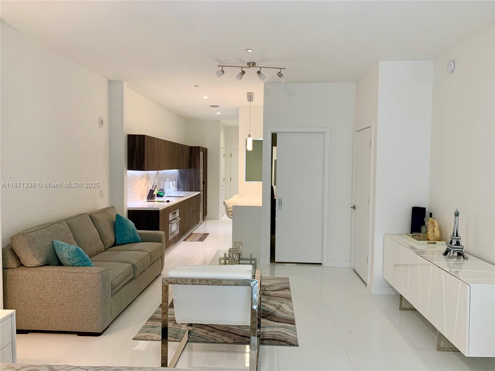 851 Northeast 1st Avenue, Unit 502 Miami, FL 33132 - Photo 2 of 48 a living room with furniture and a chandelier