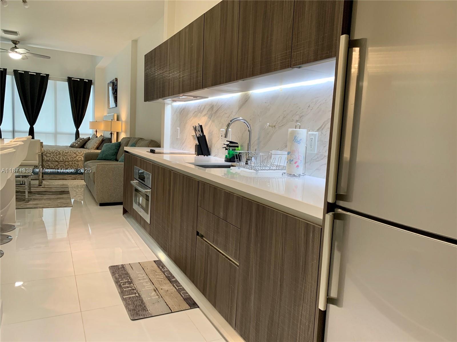 851 Northeast 1st Avenue, Unit 502 Miami, FL 33132 - Photo 6 of 48 a kitchen with a sink stainless steel appliances a counter top space and cabinets