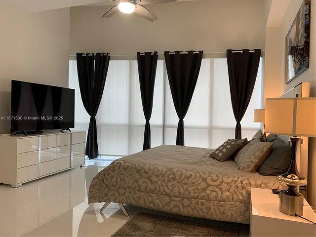 a bedroom with a bed a flat screen tv and a walk in closet