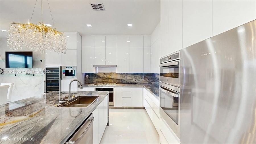 8350 Royal County Down Road Boca Raton, FL 33434 - Photo 8 of 52 a kitchen with a refrigerator a sink and a stove