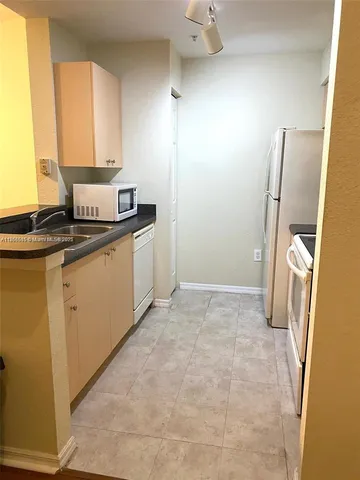 a kitchen with a stove a refrigerator and a sink