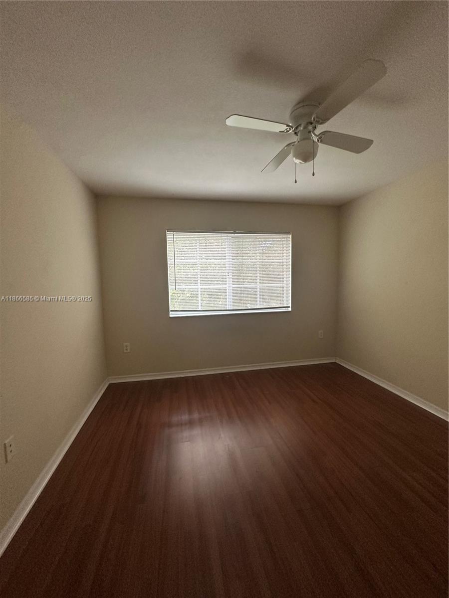 2564 Centergate Drive, Unit 304 Miramar, FL 33025 - Photo 5 of 13 an empty room with wooden floor windows and ceiling fan