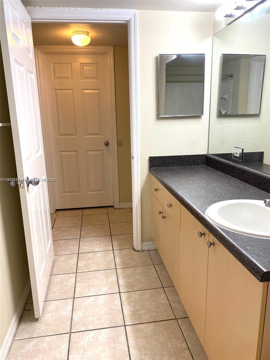 2564 Centergate Drive, Unit 304 Miramar, FL 33025 - Photo 10 of 13 a bathroom with a granite countertop sink and a mirror