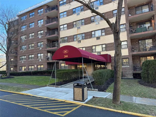 a front view of a building with street view and trees