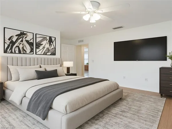a bedroom with a large bed and a flat screen tv