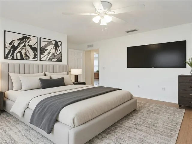 a bedroom with a large bed and a flat screen tv