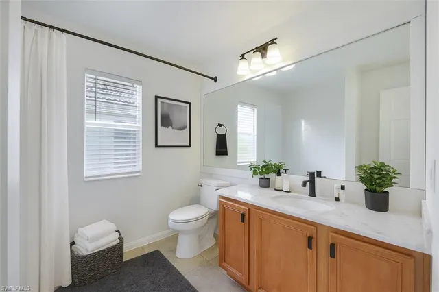 a bathroom with a granite countertop sink mirror and a toilet