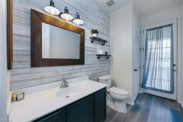a bathroom with a toilet sink and mirror