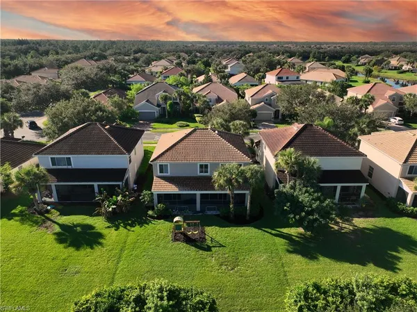 a aerial view of a house in a big yard with large trees