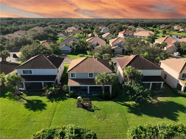 a aerial view of a house in a big yard with large trees