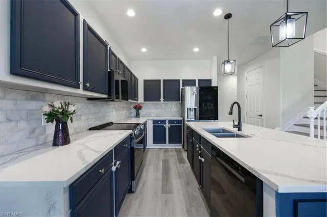 a large kitchen with stainless steel appliances a stove center island a refrigerator and a center island