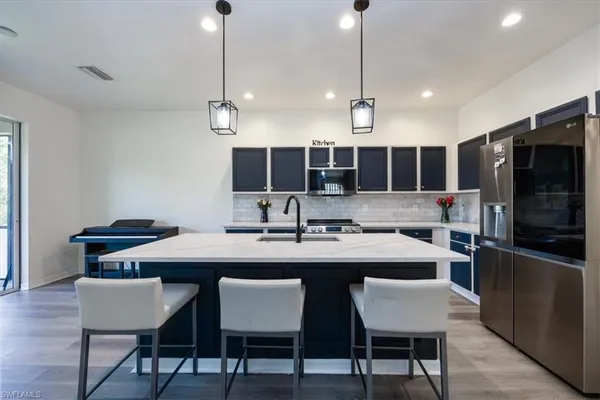 a kitchen with a dining table chairs and wooden floor