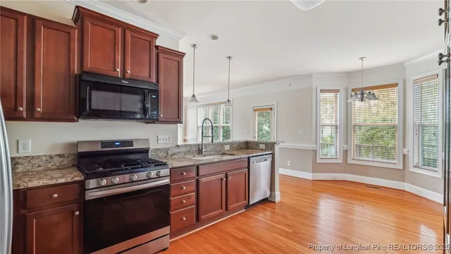 a kitchen with stainless steel appliances granite countertop a refrigerator stove and sink