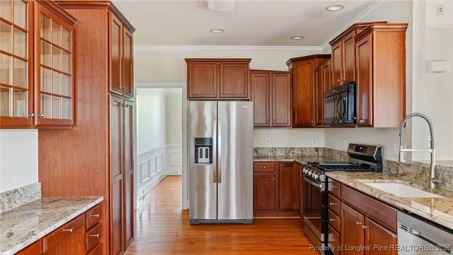 a kitchen with stainless steel appliances granite countertop a refrigerator stove and sink