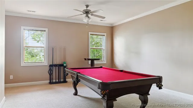 a room with pool table and windows