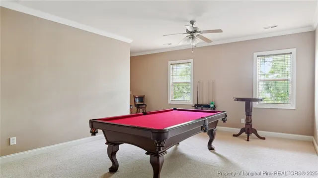 a room with pool table and windows