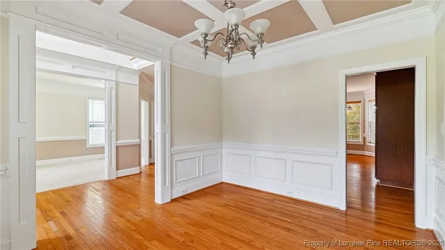 a view of an empty room with wooden floor fireplace and a window