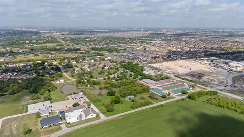 an aerial view of residential houses with outdoor space and trees