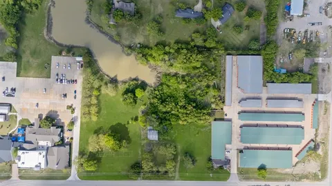 an aerial view of a house with a yard and large trees