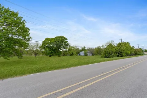 a view of a field of grass and trees