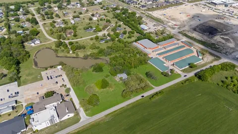 an aerial view of a residential houses with outdoor space and street view