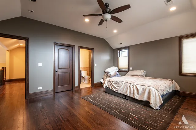 a bedroom with a large bed chandelier and a window