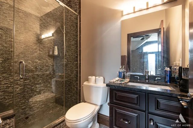 a bathroom with a granite countertop sink toilet and shower