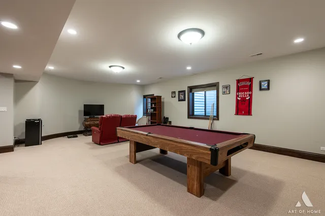 a room with furniture pool table and a flat screen tv