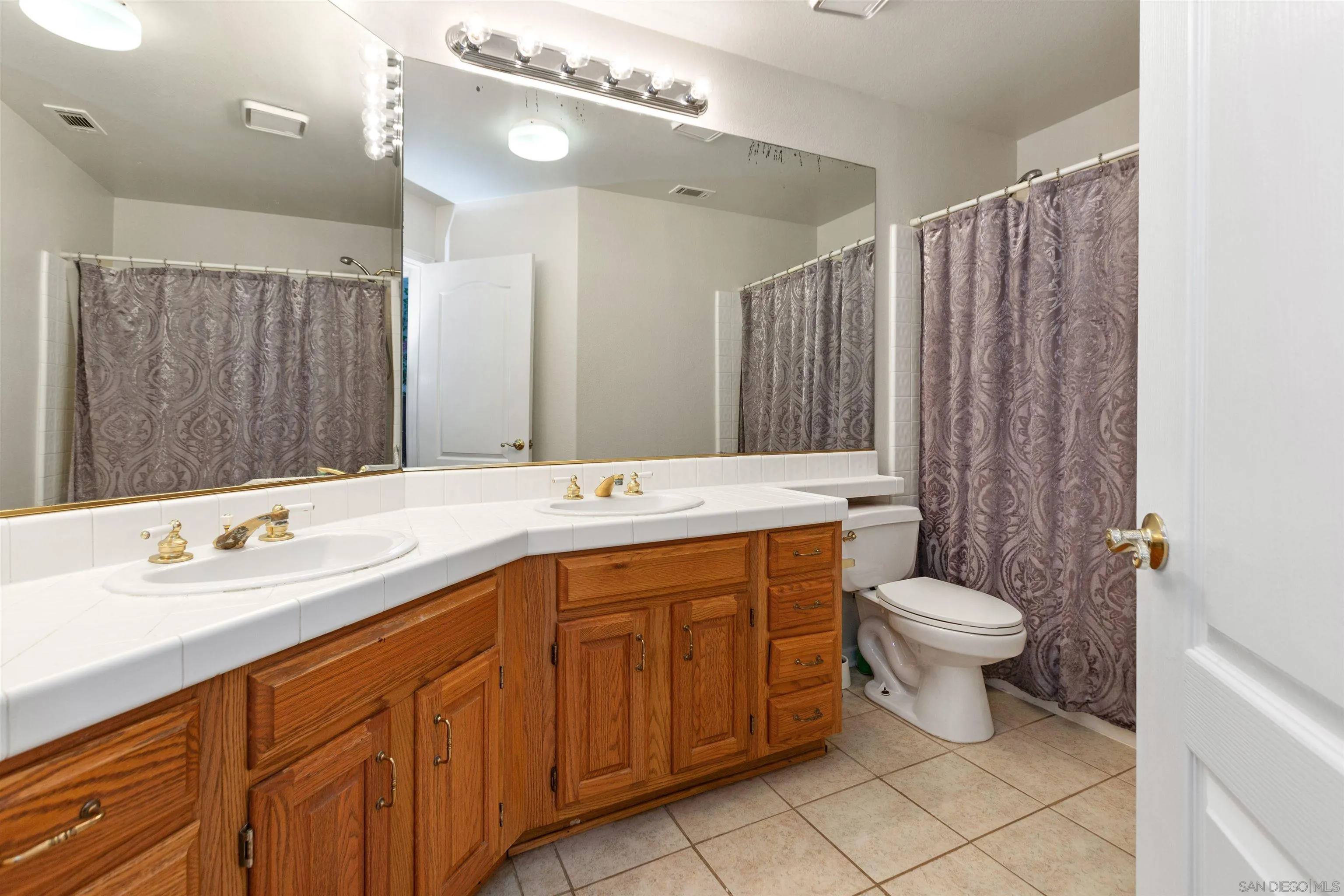 31759 Corte Rosario Temecula, CA 92592 - Photo 27 of 44 a bathroom with a double vanity sink a toilet and a mirror