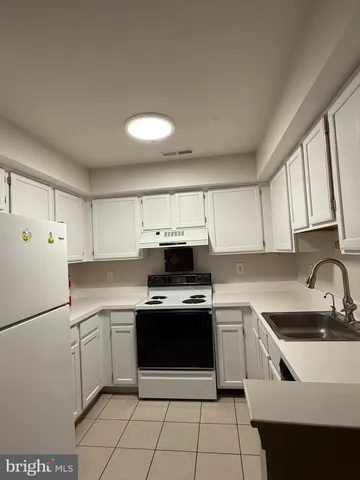a kitchen with a stove sink and cabinets