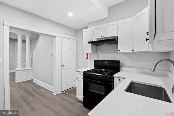 a kitchen with granite countertop a stove a sink and a refrigerator