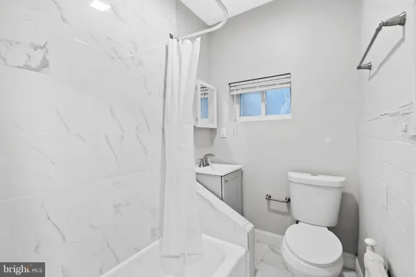 a white toilet sitting next to a white sink