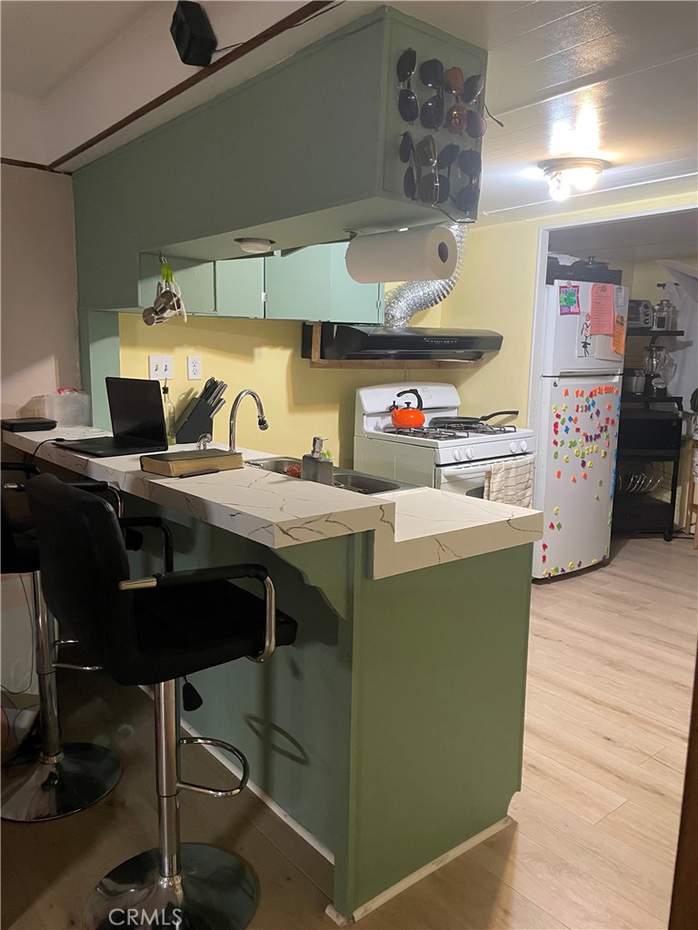 22600 Normandie Avenue, Unit 32 Torrance, CA 90502 - Photo 20 of 40 a kitchen with a stove a refrigerator and wooden floor