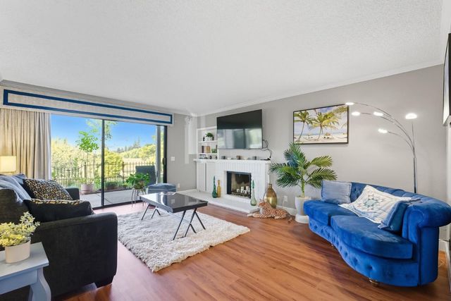 a living room with fireplace furniture and a large window