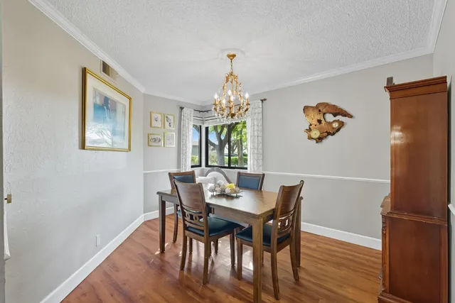 a dining room with furniture a chandelier and wooden floor