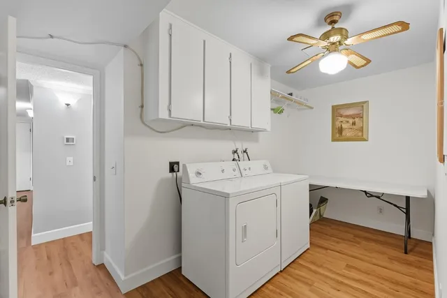 a view of a hallway with wooden floor and a workspace